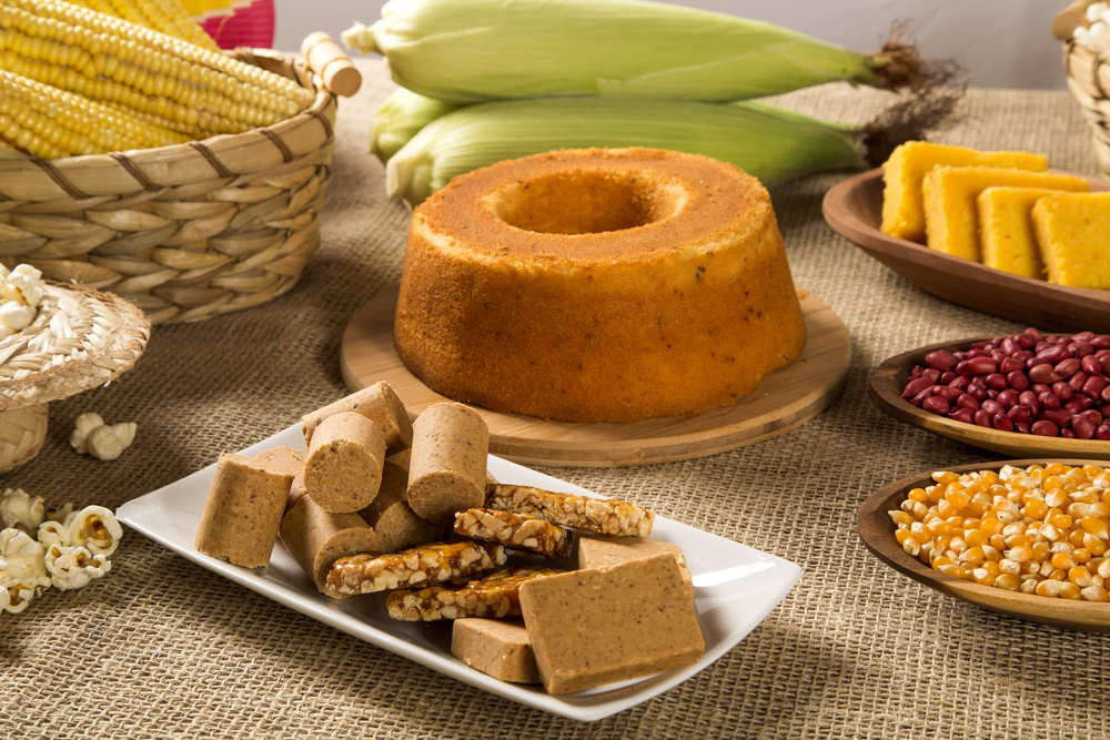 Foto de comidas típicas de festas juninas: paçoca, pipoca, milho, amendoim, bolo de fubá