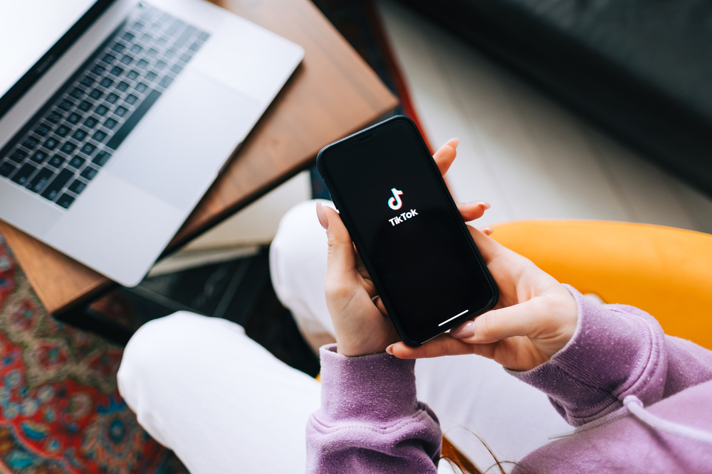 Rostov-on-Don, RUSSIA - January 25 2021 : woman holding iPhone with TikTok app logo on the screen.